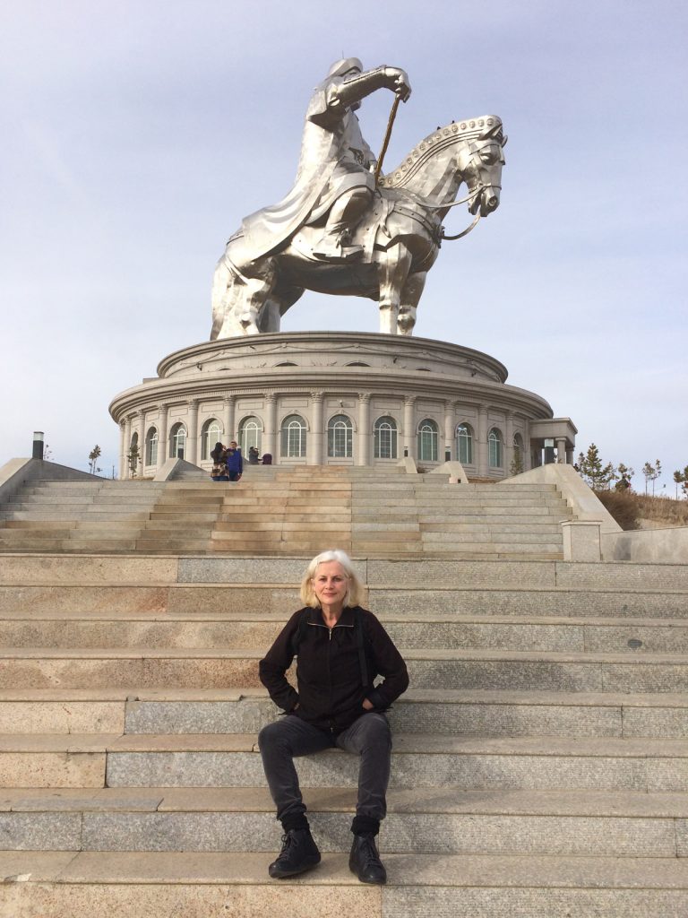 Annie Warburton on the steps in front of the big statue of Genhis Khan just out of Ulan Bataar
